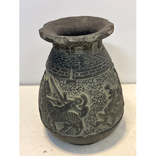 93 - Engraved ceramic vase with detailed warrior motifs. Likely handcrafted. Condition shows wear consist... 