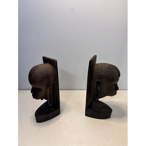 102 - Carved wooden bookends depicting heads with intricate details, in good condition.