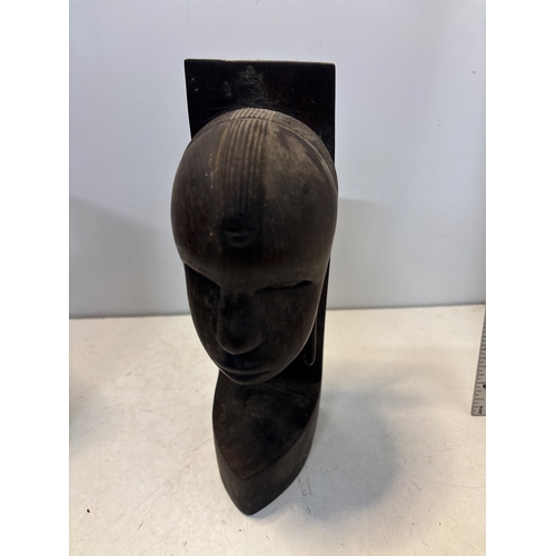 102 - Carved wooden bookends depicting heads with intricate details, in good condition.