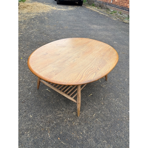 112 - Ercol wooden oval coffee table with spindle shelf design.