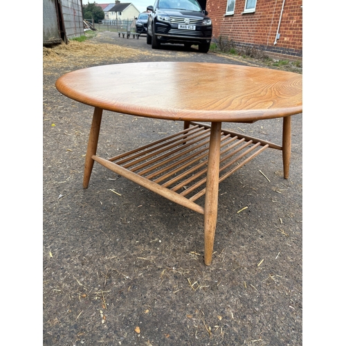 112 - Ercol wooden oval coffee table with spindle shelf design.