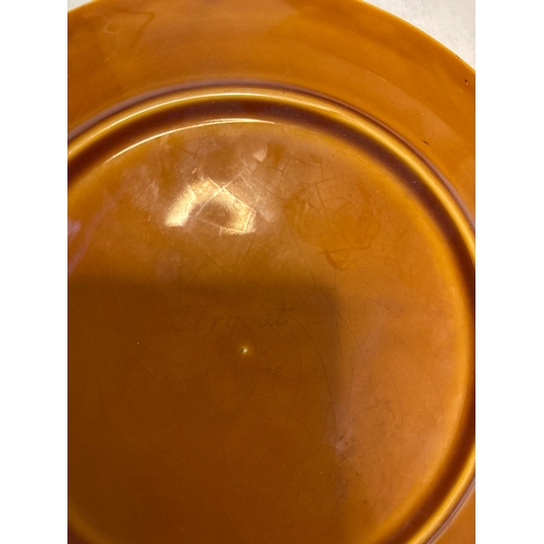 126 - Circular ceramic plate with embossed figure, glazed amber finish