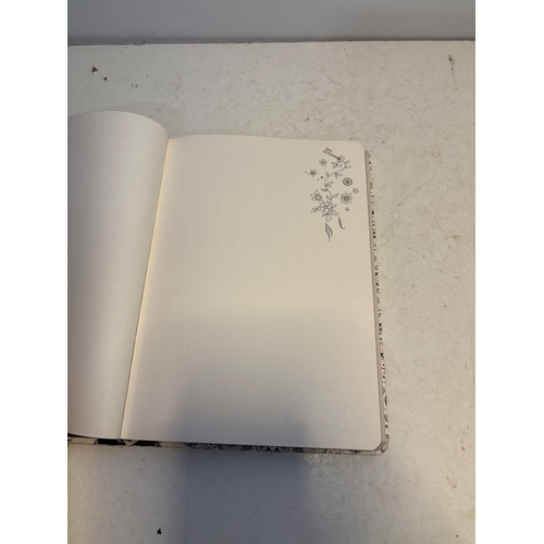 139 - Hardcover notebook with floral motif, black spine, and blank lined pages.