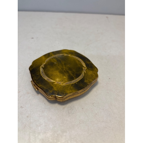 97 - Gold-tone compact with scalloped edges and engraved details, moderate wear.