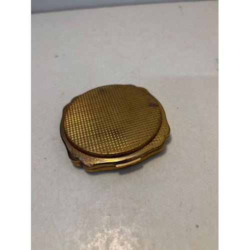 97 - Gold-tone compact with scalloped edges and engraved details, moderate wear.