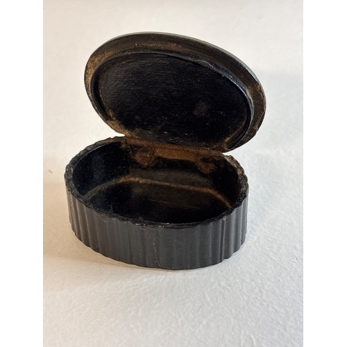 17 - Small oval black snuff box with hinged lid and pastoral scene a/f