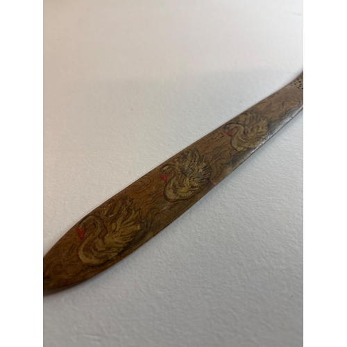 18 - Hand-carved wooden page turner with painted swans detail.