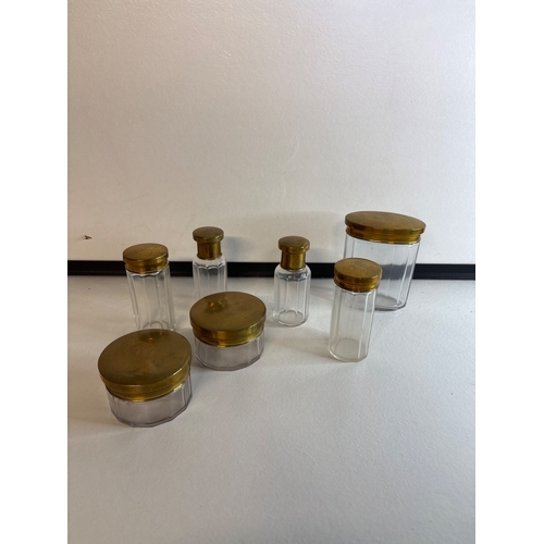 20 - Clear glass jars with brass lids.