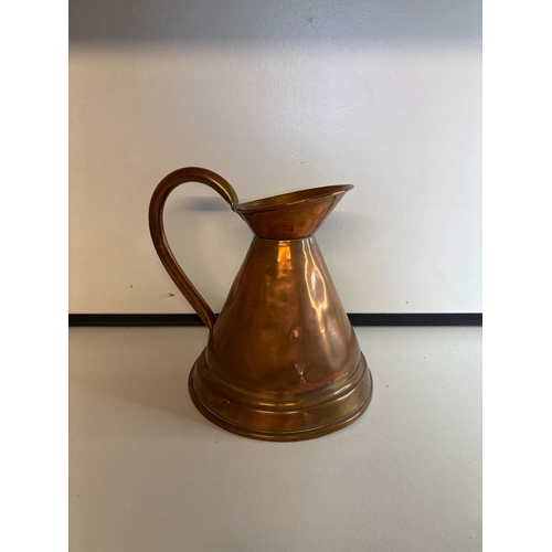 42 - Hammered copper pitcher with curved handle.