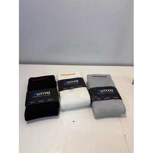 119 - Three pairs of Utiyo athletic crew socks in black, white, and gray.