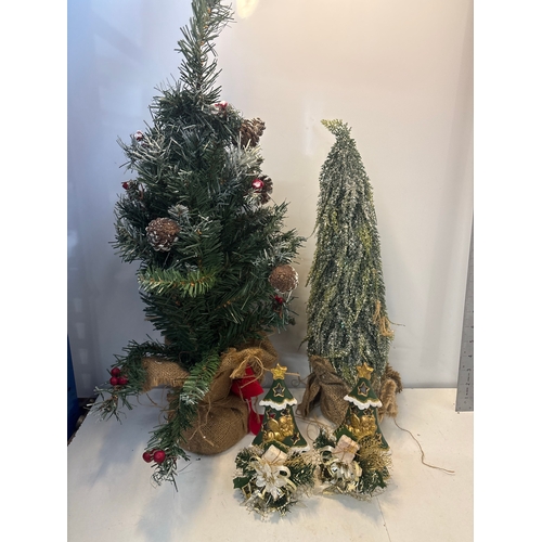 Two artificial holiday trees, one frosted and one adorned with ...