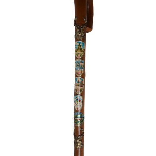 42 - Five Walking Canes - 2 with numerous badges attached, 1 with a horn handle and 2 with carved heads.