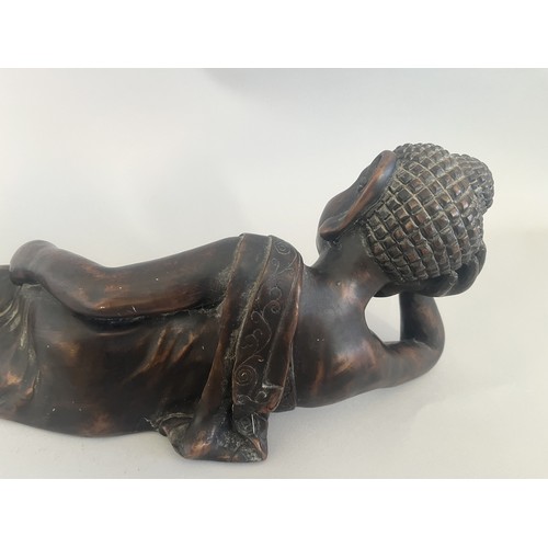 31 - A Resin Reclining Buddha Figure with Dark Bronze-Tone Finish. A resin figure of a reclining Buddha,i... 