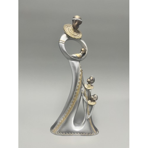 3 - Stylized Silver and Gold African Mother and Children Figurine.
A single silver- and gold-toned figur... 