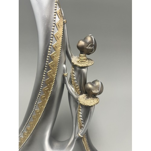 3 - Stylized Silver and Gold African Mother and Children Figurine.
A single silver- and gold-toned figur... 