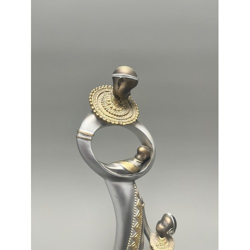 3 - Stylized Silver and Gold African Mother and Children Figurine.
A single silver- and gold-toned figur... 
