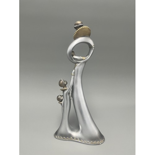 3 - Stylized Silver and Gold African Mother and Children Figurine.
A single silver- and gold-toned figur... 