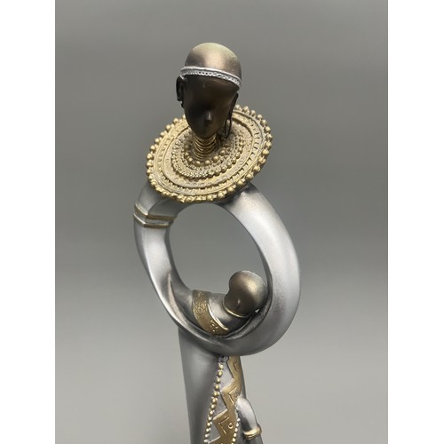 3 - Stylized Silver and Gold African Mother and Children Figurine.
A single silver- and gold-toned figur... 