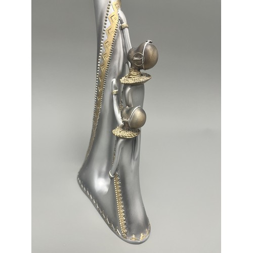 3 - Stylized Silver and Gold African Mother and Children Figurine.
A single silver- and gold-toned figur... 