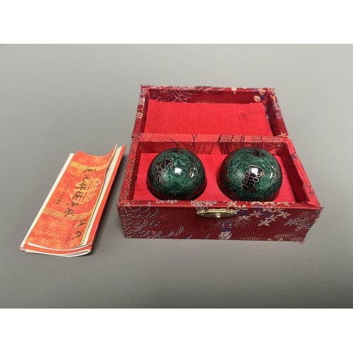 9 - A Pair of Lotus Pond Healthy Baoding Balls decorated with gold motifs, stored in a red fabric box la... 