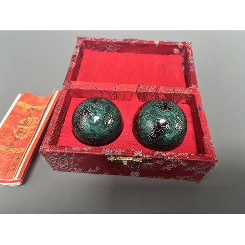 9 - A Pair of Lotus Pond Healthy Baoding Balls decorated with gold motifs, stored in a red fabric box la... 