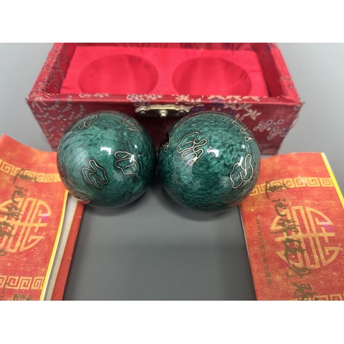 9 - A Pair of Lotus Pond Healthy Baoding Balls decorated with gold motifs, stored in a red fabric box la... 