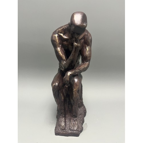 37 - A bronze style resin figure of 'The Thinking Man' by Auguste Rodin. 32 cms tall. Detailed and in goo... 