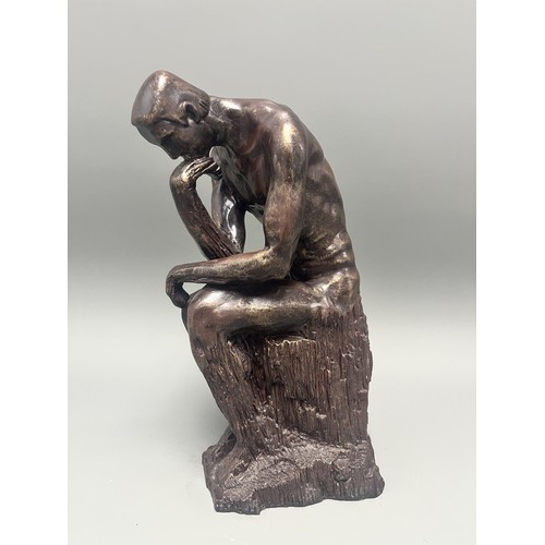 37 - A bronze style resin figure of 'The Thinking Man' by Auguste Rodin. 32 cms tall. Detailed and in goo... 