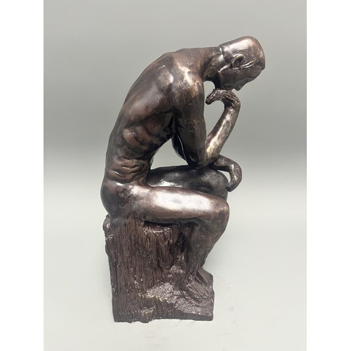 37 - A bronze style resin figure of 'The Thinking Man' by Auguste Rodin. 32 cms tall. Detailed and in goo... 