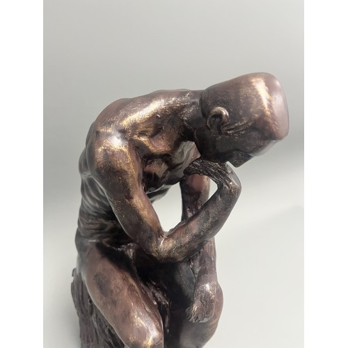 37 - A bronze style resin figure of 'The Thinking Man' by Auguste Rodin. 32 cms tall. Detailed and in goo... 