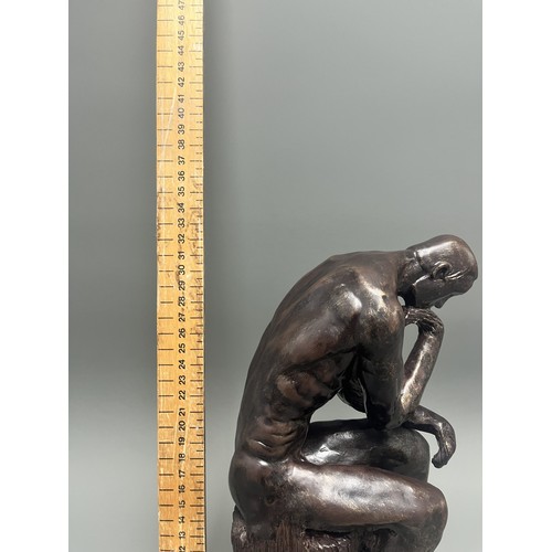 37 - A bronze style resin figure of 'The Thinking Man' by Auguste Rodin. 32 cms tall. Detailed and in goo... 