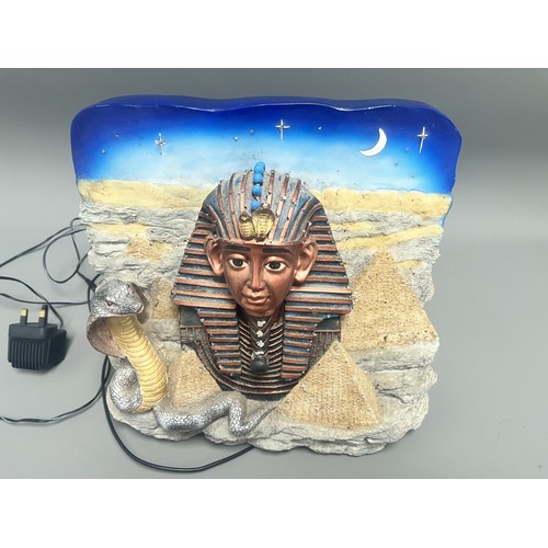 50 - An Egyptian Revival Illuminated Wall Plaque Depicting Tutankhamun's Mask. A single modern illuminate... 
