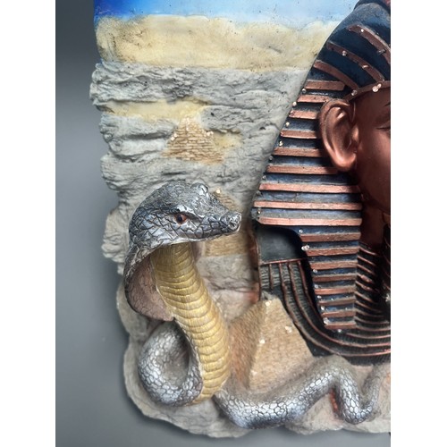 50 - An Egyptian Revival Illuminated Wall Plaque Depicting Tutankhamun's Mask. A single modern illuminate... 
