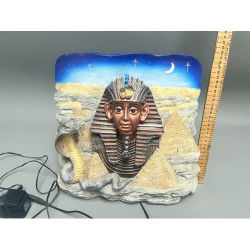50 - An Egyptian Revival Illuminated Wall Plaque Depicting Tutankhamun's Mask. A single modern illuminate... 