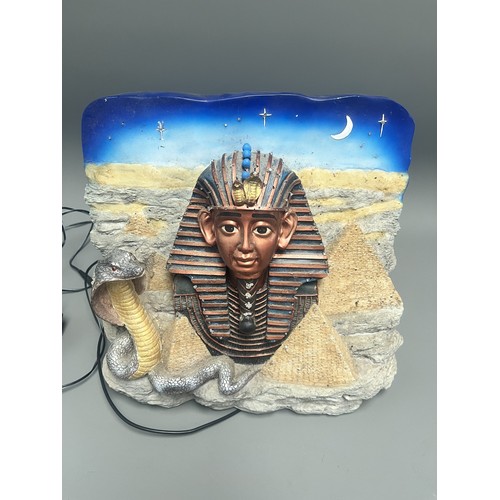 50 - An Egyptian Revival Illuminated Wall Plaque Depicting Tutankhamun's Mask. A single modern illuminate... 