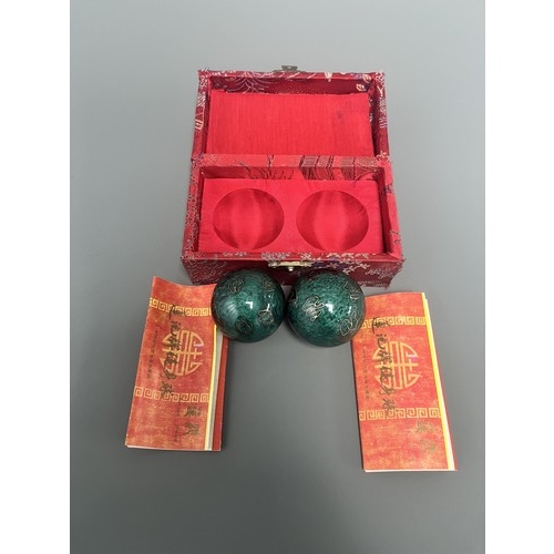 9 - A Pair of Lotus Pond Healthy Baoding Balls decorated with gold motifs, stored in a red fabric box la... 