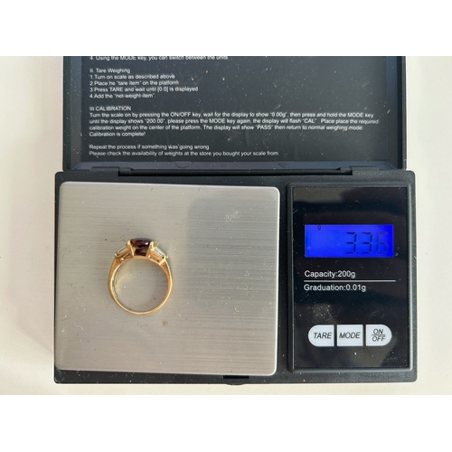 107 - 9ct Gold Garnet and Tapered Baguette Cut Diamond Ring - Fully hallmarked
