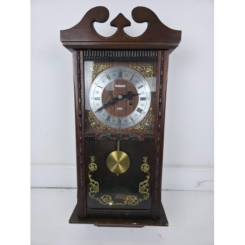 214 - Talisman 8 Day Wall Clock With Pendulum in Carved Wooden Case