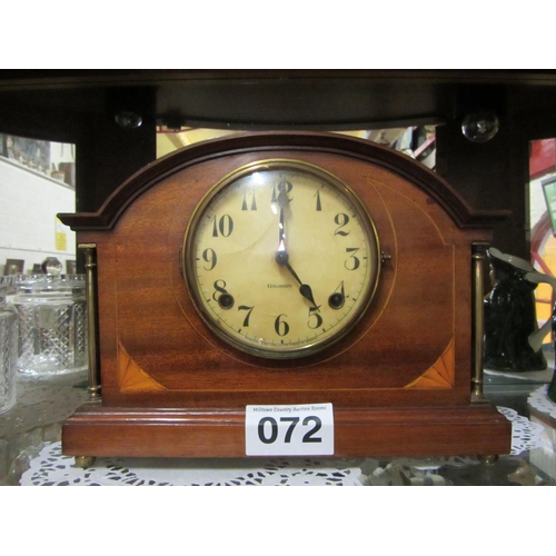 72 - Edwardian mahogany inlaid arch top mantel clock with brass pillar supports and brass feet.