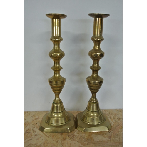 401 - A pair of antique brass candlesticks.