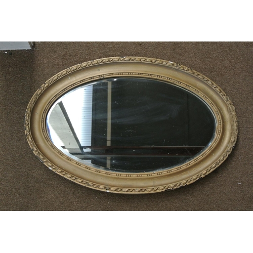 82 - An antique oval gilt framed mirror.