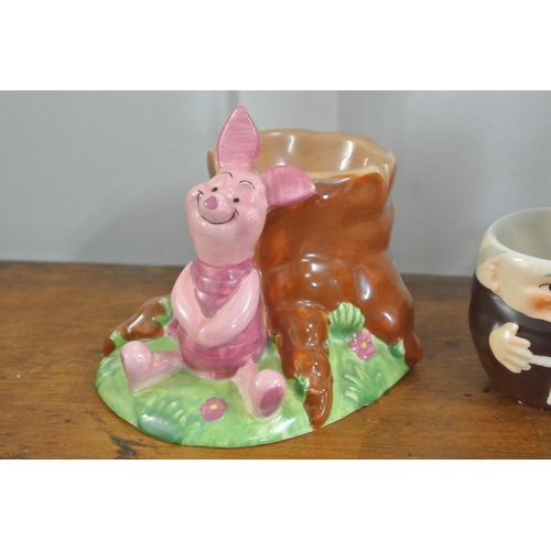 272 - A collection of 5 decorative egg cups, to include a Disney Piglet piece, 3 Goebel Hummel Monks & a H... 