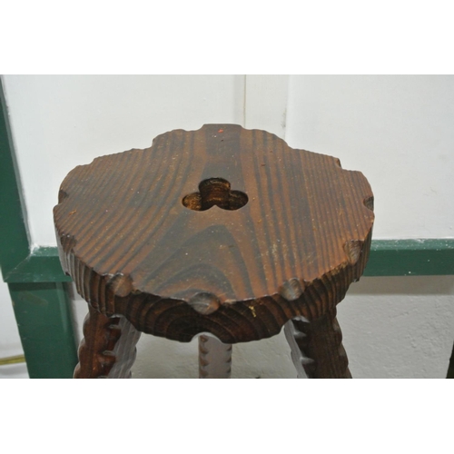 331 - An antique carved wooden milking stool.