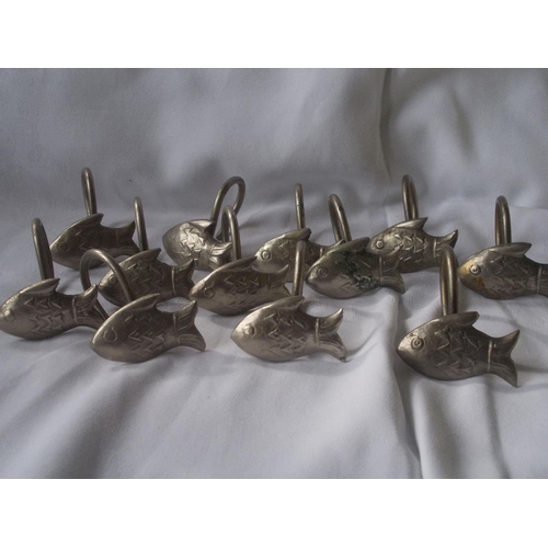 445 - A matching set of white metal shower curtain hooks designed as fish.