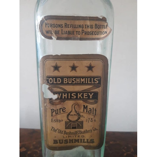 151b - An antique glass Bushmills Whiskey bottle with original paper labels, with unusual Established 1784 ... 