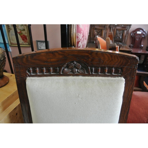 130 - An antique bedroom chair with decorative wooden frame & recent reupholstry.