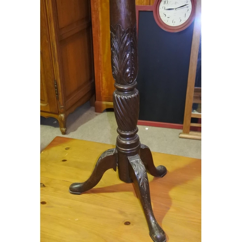 482 - An antique Torchere  with decorative carvings on tripod base.