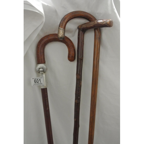 601 - A collection of 3 walking sticks, to include one with silver collar.