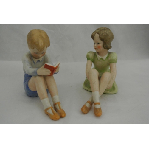 628 - A pair of ceramic figures, modelled as a boy & girl.