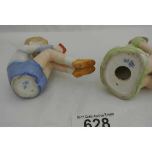 628 - A pair of ceramic figures, modelled as a boy & girl.